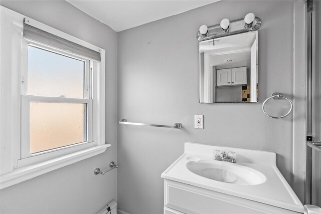 bathroom with vanity, baseboard heating, and a wealth of natural light