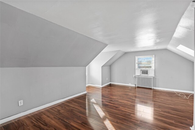 additional living space featuring dark hardwood / wood-style floors, radiator, and vaulted ceiling