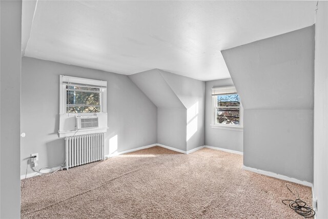 additional living space with carpet flooring, cooling unit, radiator, and lofted ceiling