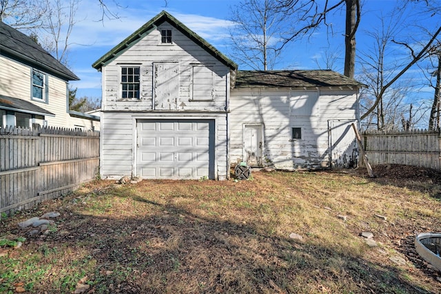 rear view of property featuring an outbuilding and a garage