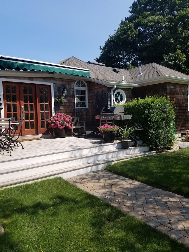 rear view of house featuring a deck, a yard, and french doors