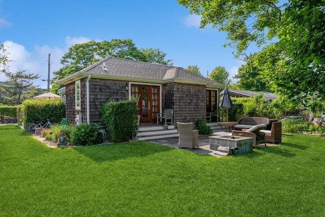 back of property with a lawn, french doors, a patio, and an outdoor fire pit