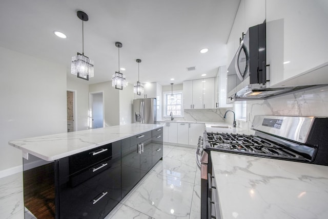 kitchen featuring sink, hanging light fixtures, decorative backsplash, white cabinets, and appliances with stainless steel finishes