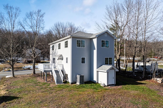 view of side of property featuring a yard, a deck, and central air condition unit