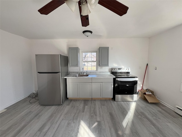 kitchen with sink, light hardwood / wood-style flooring, ceiling fan, gray cabinets, and appliances with stainless steel finishes