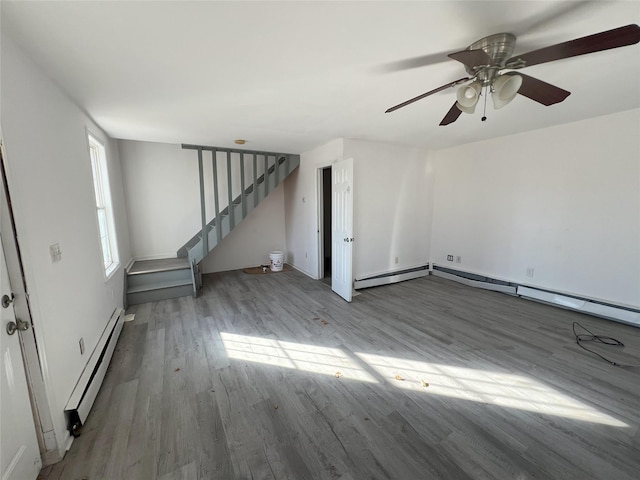 interior space featuring hardwood / wood-style floors, ceiling fan, and baseboard heating