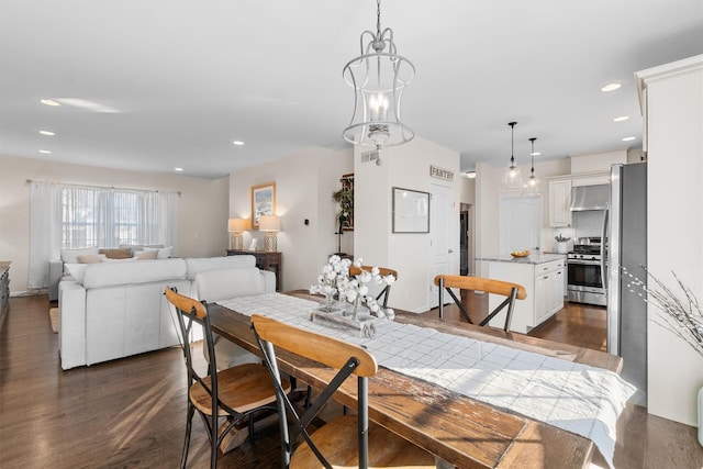 dining space with dark wood-type flooring and a notable chandelier