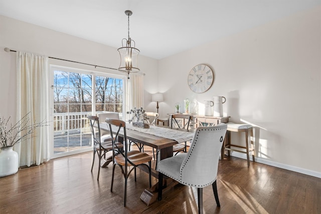 dining space with dark hardwood / wood-style floors and an inviting chandelier