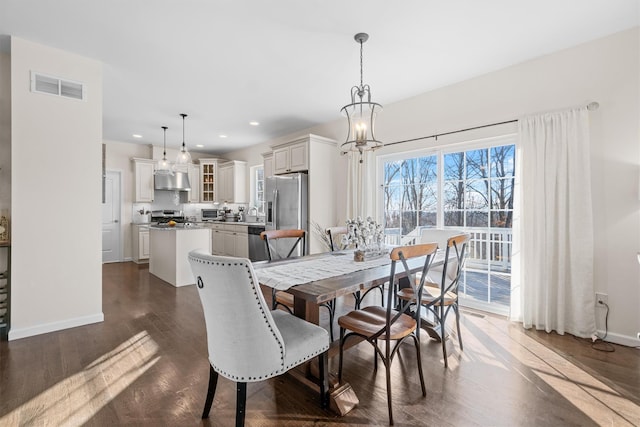 dining space featuring dark hardwood / wood-style flooring and a chandelier