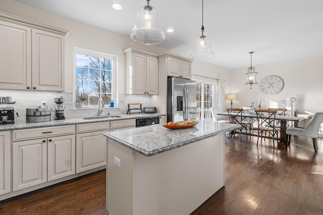 kitchen featuring tasteful backsplash, a kitchen island, stainless steel fridge with ice dispenser, white cabinetry, and hanging light fixtures