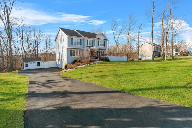 view of front of property featuring a garage, an outbuilding, and a front yard