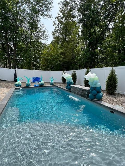 view of swimming pool with pool water feature