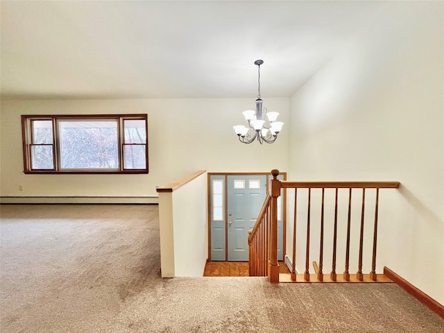 carpeted entrance foyer with a chandelier and baseboard heating