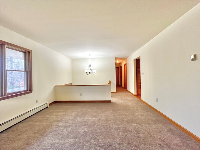 spare room featuring carpet flooring, a chandelier, and a baseboard radiator