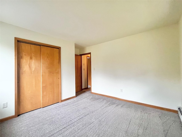 unfurnished bedroom featuring light carpet, a closet, and a baseboard radiator