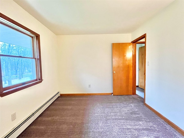 spare room featuring carpet flooring and a baseboard heating unit