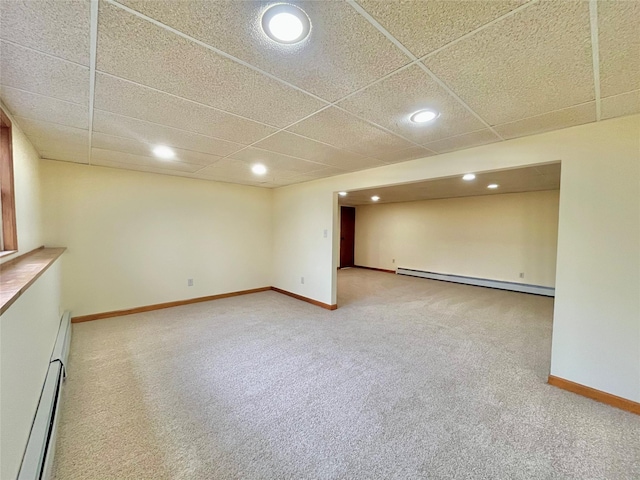 basement featuring baseboard heating, a paneled ceiling, and carpet floors