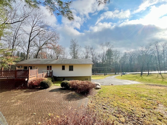 view of side of home with a lawn and a wooden deck