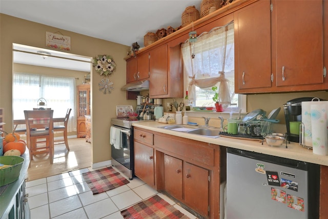 kitchen with light tile patterned flooring, stainless steel appliances, and sink