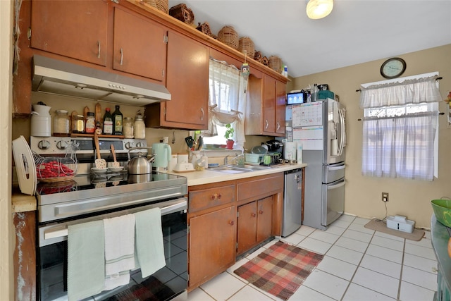 kitchen featuring light tile patterned flooring, stainless steel appliances, and sink