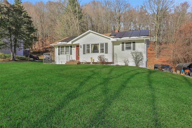 single story home featuring solar panels and a front lawn