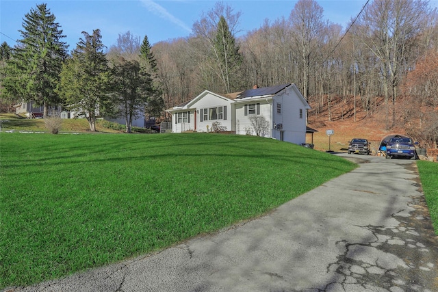 view of front of house with solar panels and a front lawn