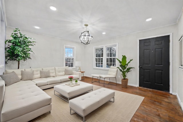 living area with crown molding, recessed lighting, wood finished floors, a notable chandelier, and baseboards