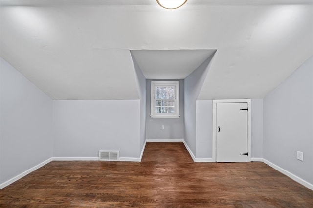 bonus room featuring visible vents, baseboards, wood finished floors, and lofted ceiling