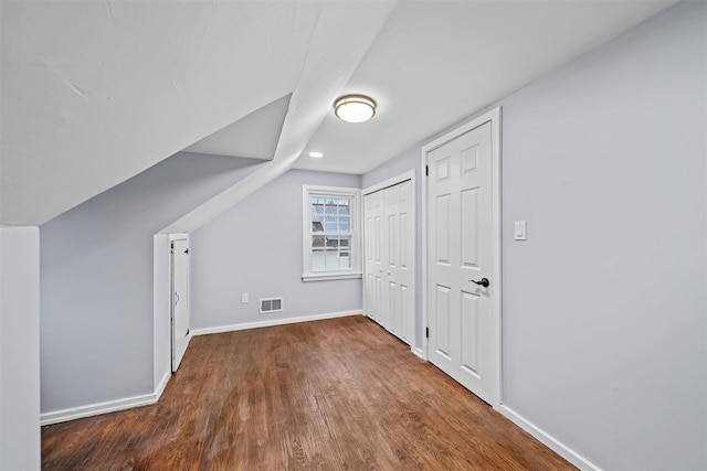 bonus room with visible vents, baseboards, vaulted ceiling, and wood finished floors