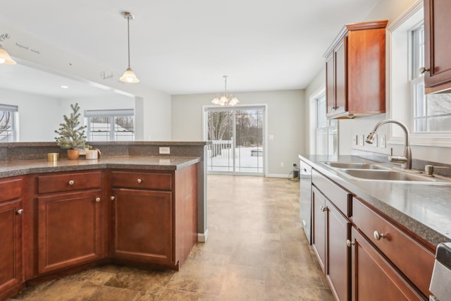 kitchen with white dishwasher, sink, hanging light fixtures, and a notable chandelier