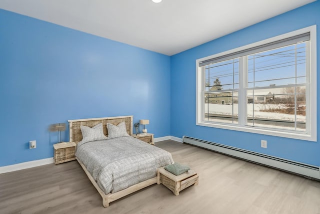 bedroom featuring a baseboard radiator and wood-type flooring