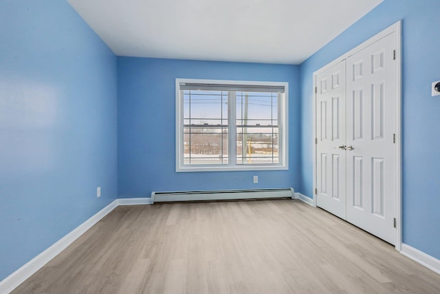 spare room with light hardwood / wood-style flooring and baseboard heating