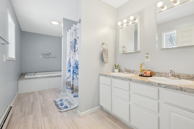 bathroom featuring a baseboard radiator, hardwood / wood-style floors, and vanity