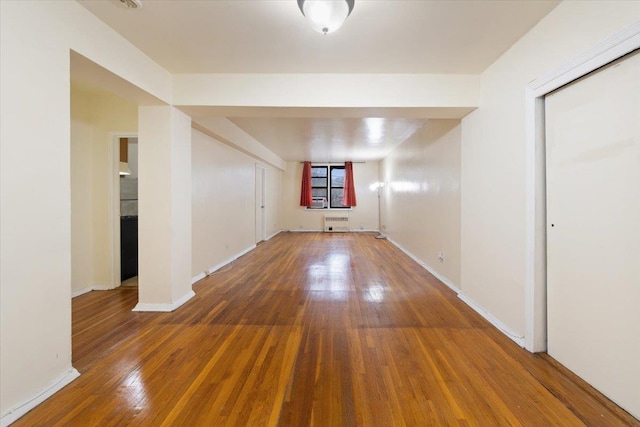 spare room featuring radiator and dark hardwood / wood-style floors