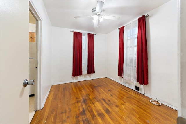 empty room with hardwood / wood-style flooring and ceiling fan