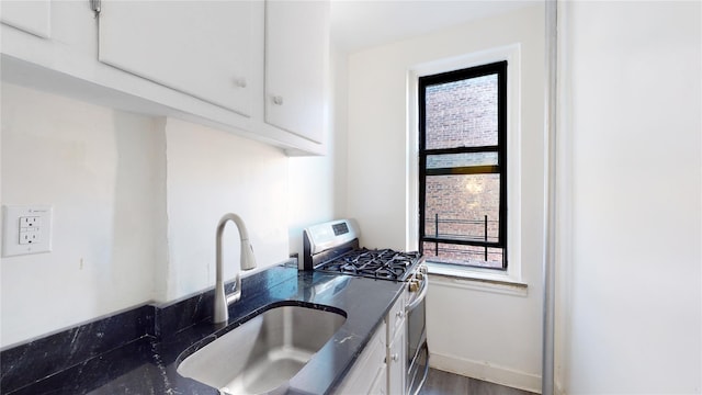 3000 Valentine Ave Unit 4E, Bronx, NY 10458 - kitchen with gas range, a sink, white cabinetry, and baseboards
