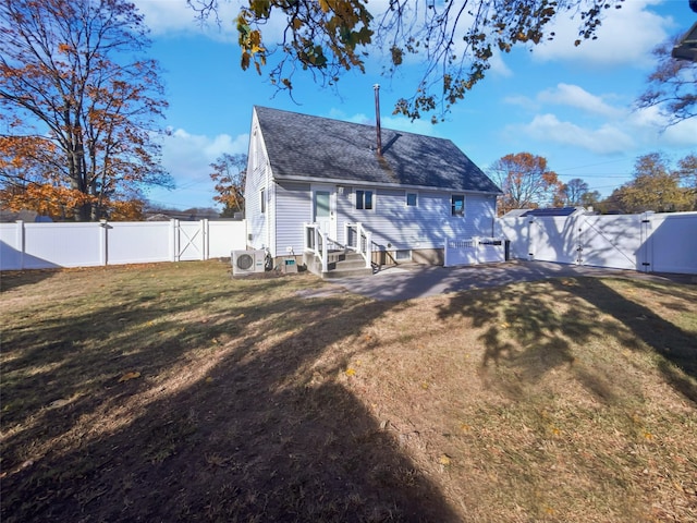 back of house with ac unit and a yard