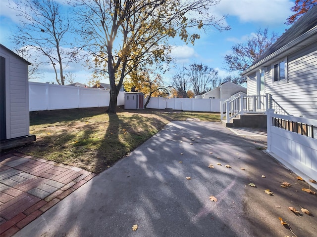 view of yard with a shed and a patio area