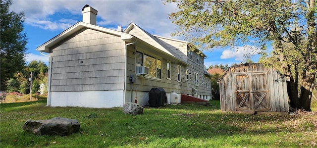 view of home's exterior with a lawn, cooling unit, and a shed