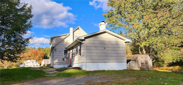 view of property exterior with a lawn and a shed