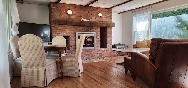 interior space with wood-type flooring, a fireplace, and brick wall