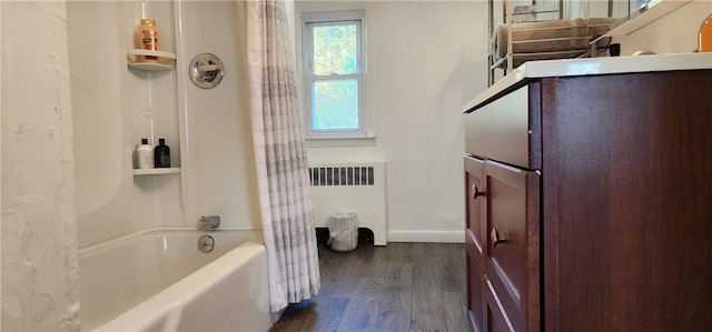 bathroom featuring radiator, shower / bath combination with curtain, and hardwood / wood-style flooring