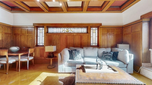 living room featuring wooden walls, light hardwood / wood-style flooring, beamed ceiling, and coffered ceiling