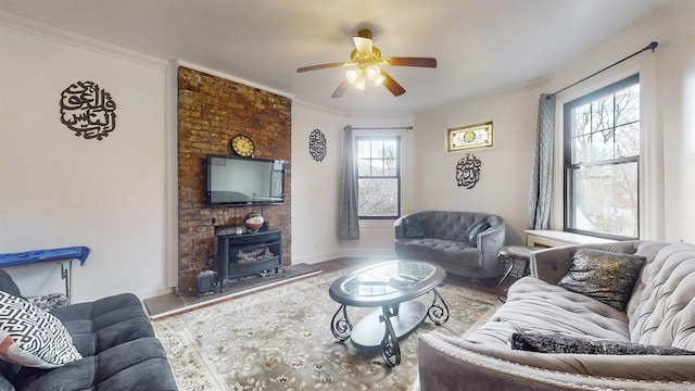 living room featuring a wood stove, ceiling fan, plenty of natural light, and wood-type flooring