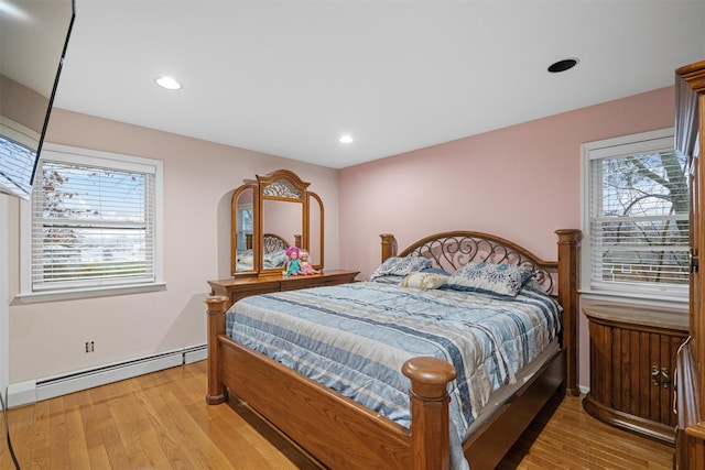 bedroom featuring baseboard heating and light hardwood / wood-style floors