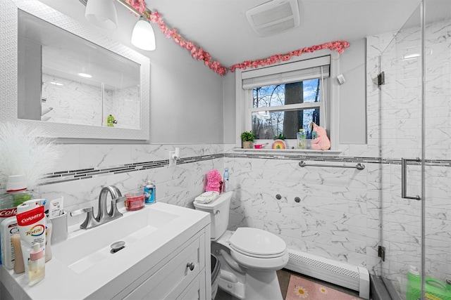 bathroom with a baseboard radiator, toilet, a shower with door, vanity, and tile walls