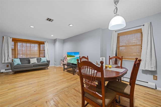 dining room featuring a baseboard radiator and light hardwood / wood-style flooring