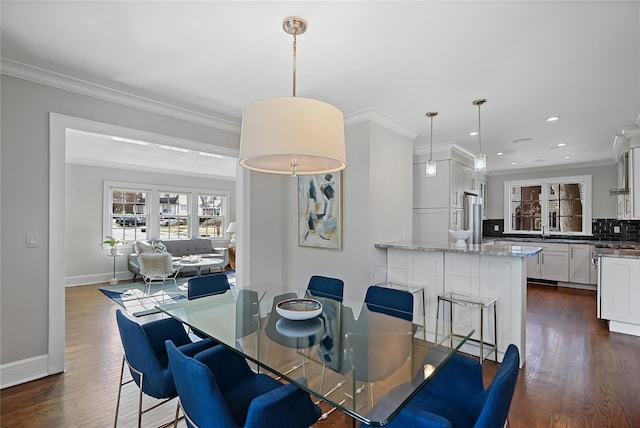 dining room with sink, dark wood-type flooring, and ornamental molding