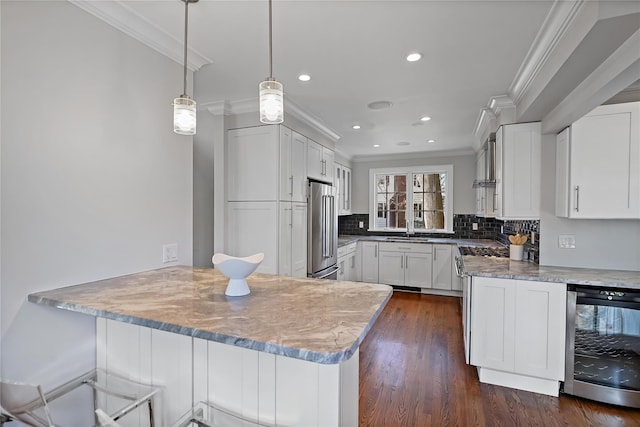 kitchen with wine cooler, high quality fridge, and white cabinetry