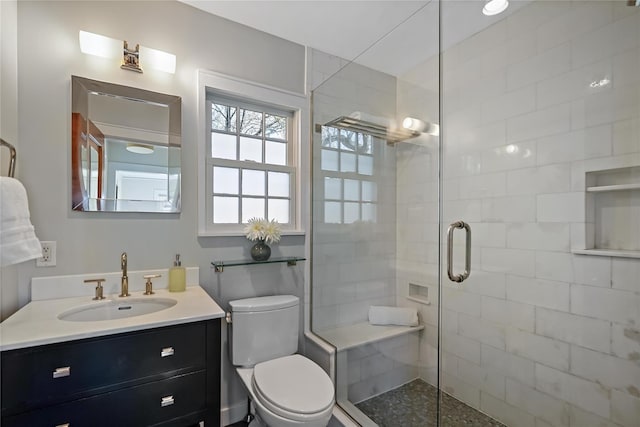 bathroom featuring vanity, toilet, and a shower with shower door